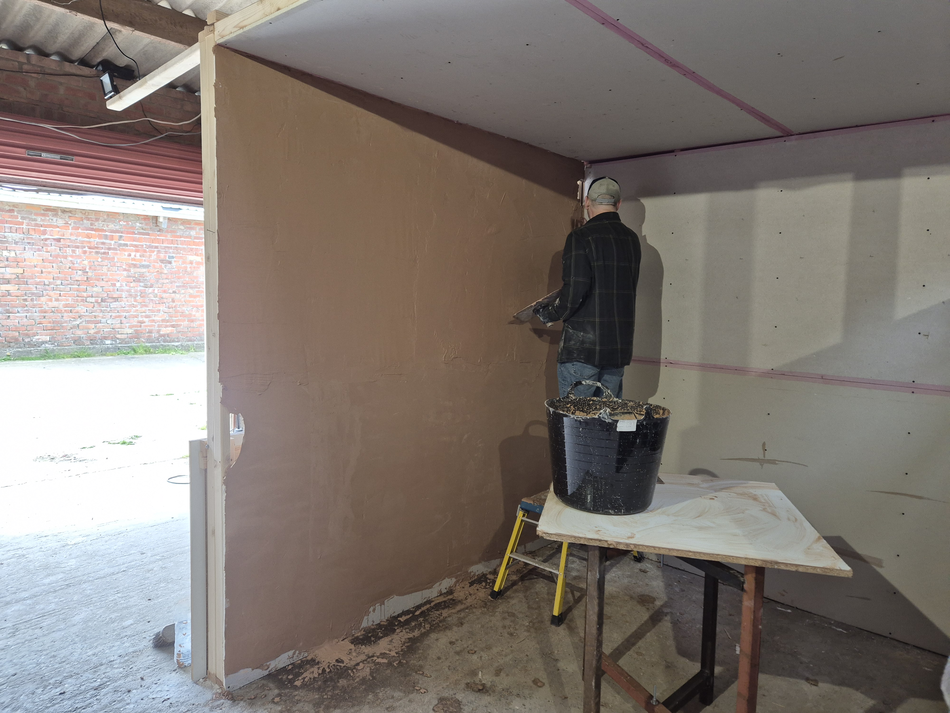Plastering course participant finishing a training wall in the workshop